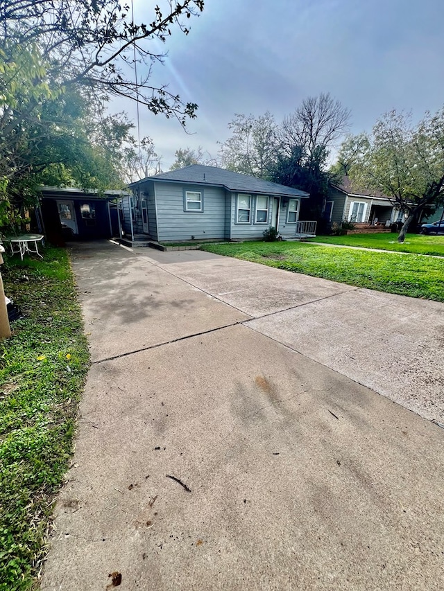 ranch-style home with a carport and a front lawn