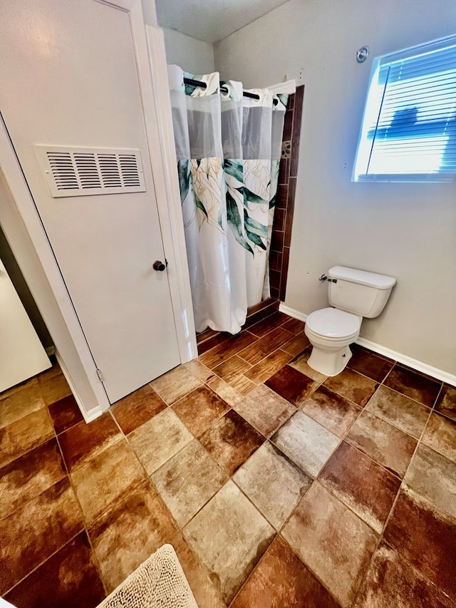 bathroom with curtained shower and toilet