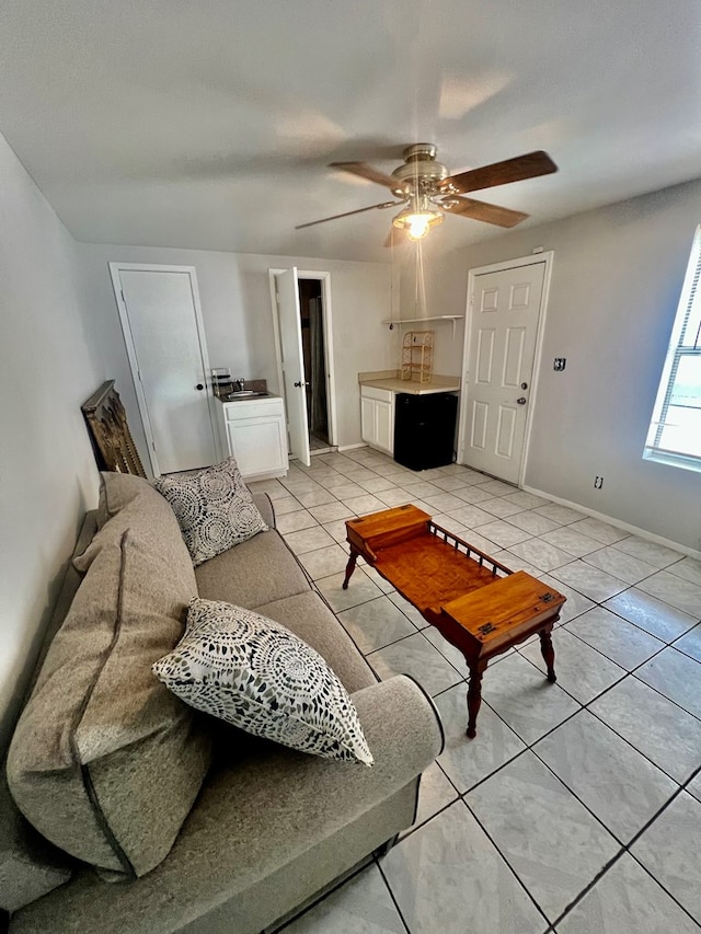 living room with washer / clothes dryer, ceiling fan, and light tile patterned flooring