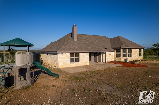 rear view of property featuring a patio area and a playground