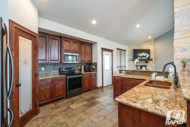 kitchen with sink, appliances with stainless steel finishes, tasteful backsplash, light stone counters, and vaulted ceiling