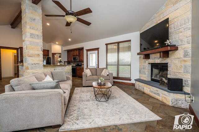 living room featuring vaulted ceiling with beams, a fireplace, and ceiling fan