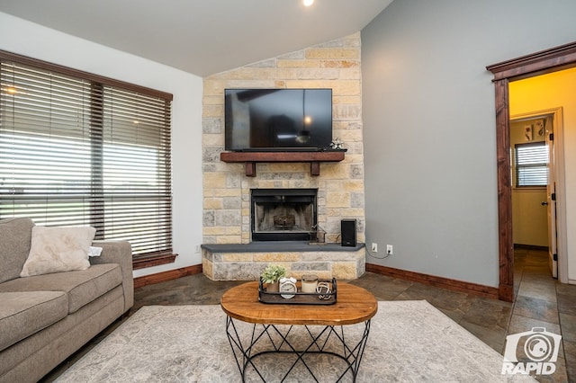 living room with a stone fireplace and vaulted ceiling