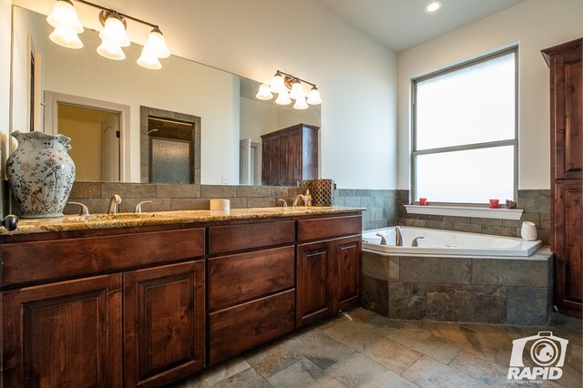 bathroom featuring vanity and tiled bath