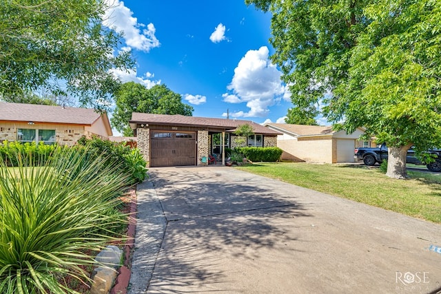 1103 E 43rd St, San Angelo, TX 76903 - view of front of house featuring concrete driveway, an attached garage, a front yard, and brick siding