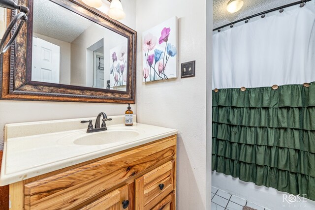 1103 E 43rd St, San Angelo, TX 76903 - full bathroom with a textured ceiling, vanity, and tile patterned flooring