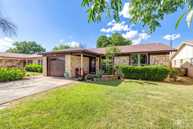 1103 E 43rd St, San Angelo, TX 76903 - ranch-style house featuring a garage, brick siding, a front lawn, and concrete driveway