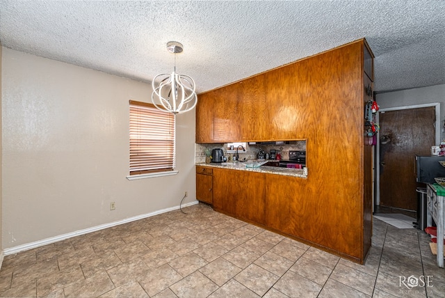 1103 E 43rd St, San Angelo, TX 76903 - kitchen with brown cabinetry, a chandelier, a textured ceiling, black / electric stove, and hanging light fixtures