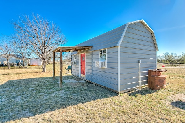 view of outbuilding featuring cooling unit and a yard