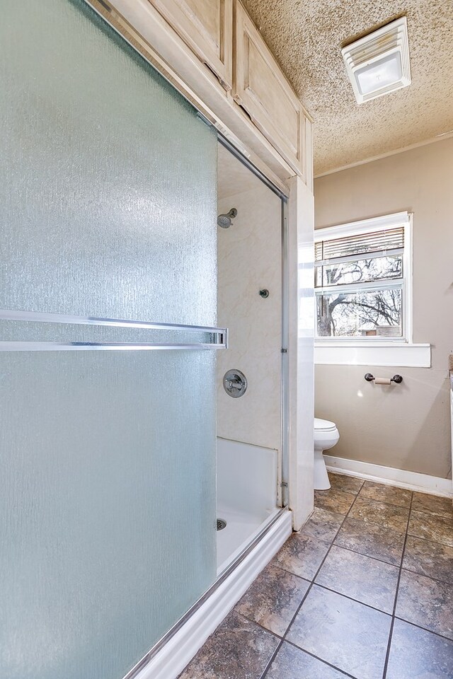 bathroom with toilet, a textured ceiling, and walk in shower