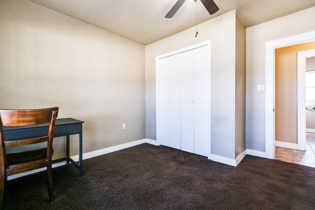 bedroom with dark colored carpet, ceiling fan, and a closet