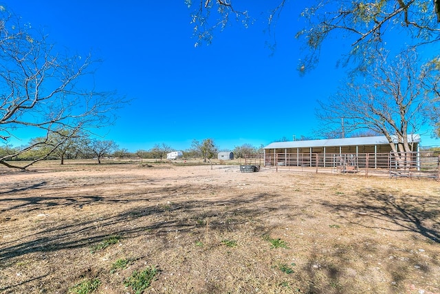 view of yard featuring a rural view and an outbuilding