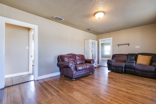 living room featuring hardwood / wood-style floors and a textured ceiling