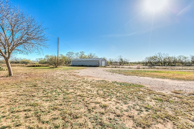 view of yard with a rural view and an outdoor structure