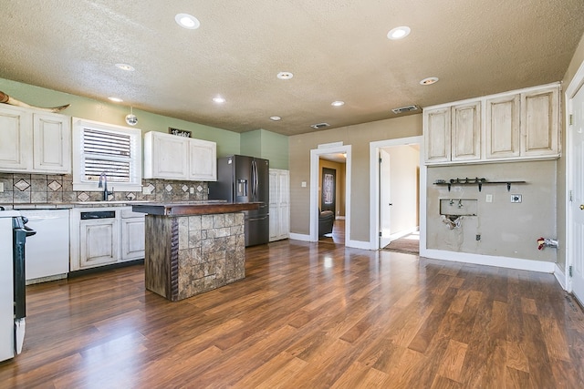 kitchen with sink, dark wood-type flooring, stainless steel fridge, and backsplash