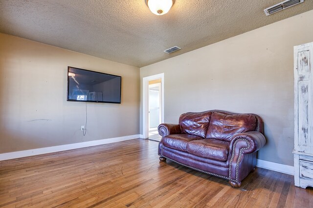 living room featuring hardwood / wood-style floors and a textured ceiling