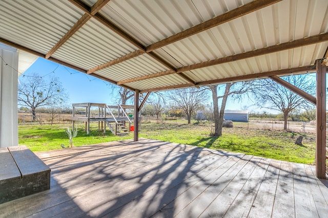 wooden deck featuring a rural view and a yard