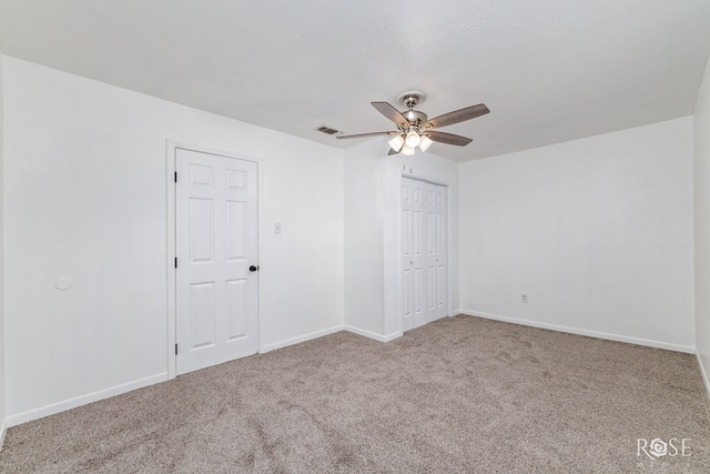 spare room featuring light colored carpet and ceiling fan