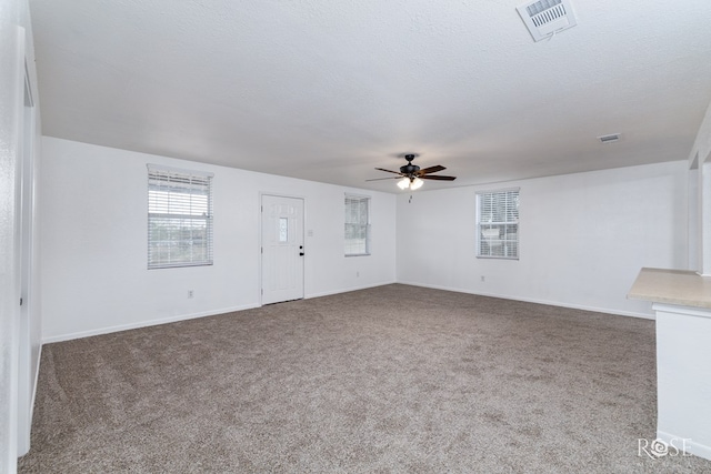 unfurnished living room featuring ceiling fan, carpet, and a textured ceiling