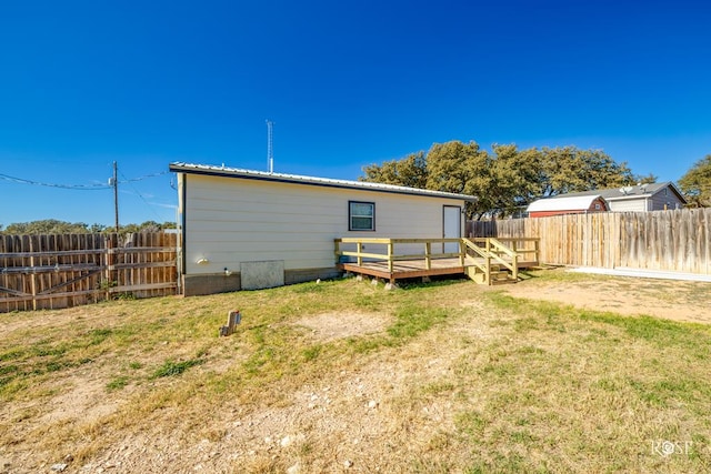 back of house with a deck and a lawn