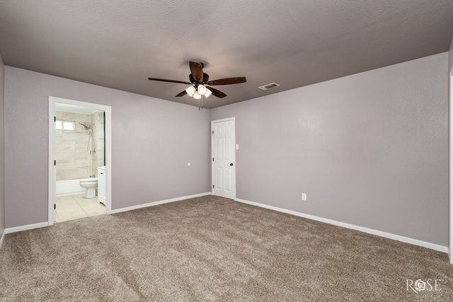 unfurnished bedroom featuring ceiling fan, connected bathroom, carpet, and a textured ceiling