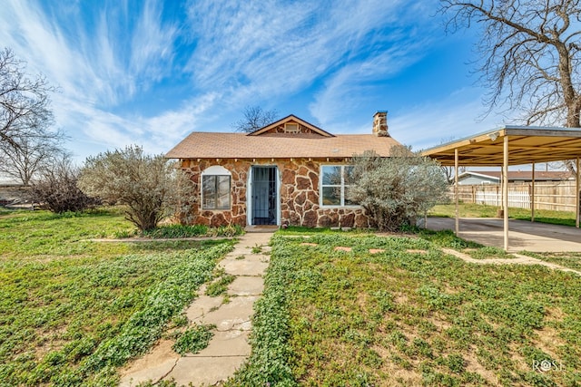 ranch-style home featuring a carport and a front yard