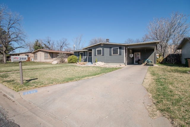 view of front of property featuring driveway, an attached carport, and a front lawn