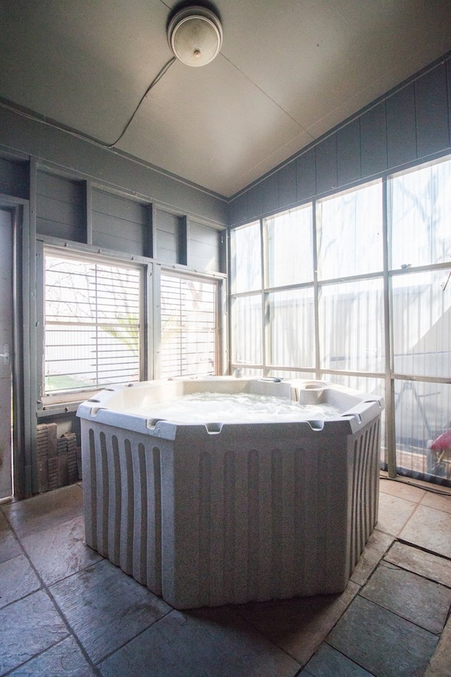 unfurnished sunroom featuring a jacuzzi and lofted ceiling