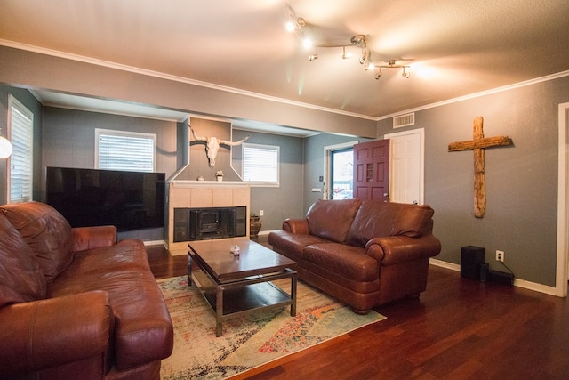 living area featuring baseboards, wood finished floors, a fireplace, and ornamental molding