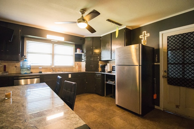 kitchen featuring crown molding, dishwasher, freestanding refrigerator, dark cabinetry, and a sink