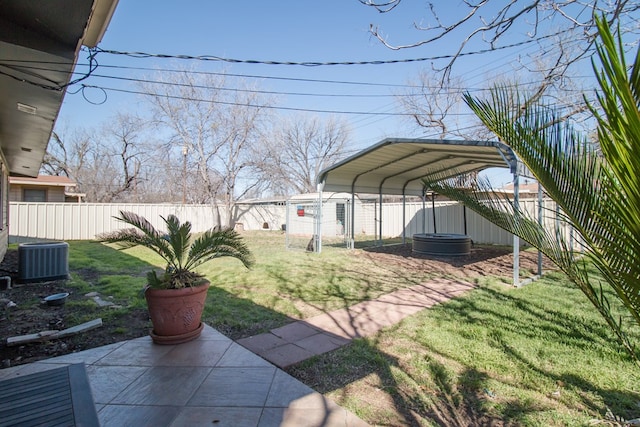 view of yard featuring a carport, central AC unit, and a fenced backyard