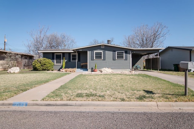 view of front of home with an attached carport, driveway, a front lawn, and fence