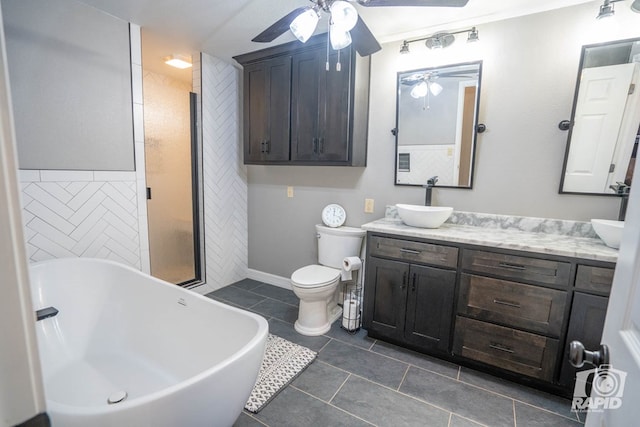 bathroom featuring vanity, a bath, ceiling fan, and toilet