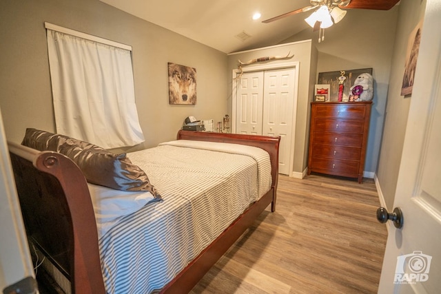 bedroom featuring ceiling fan, vaulted ceiling, a closet, and light wood-type flooring