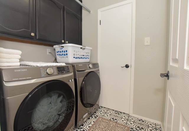 laundry area featuring baseboards, cabinet space, light tile patterned flooring, and washing machine and clothes dryer