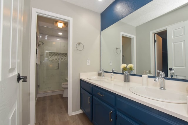 bathroom with vanity, hardwood / wood-style floors, toilet, and walk in shower