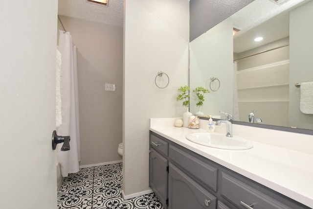 full bathroom with vanity, baseboards, a textured ceiling, tile patterned floors, and toilet