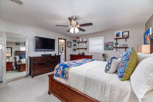 carpeted bedroom with ceiling fan and a textured ceiling