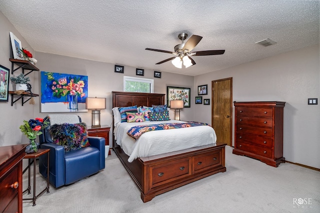 bedroom with light colored carpet, a textured ceiling, and ceiling fan