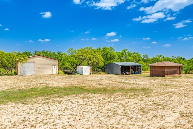 view of yard featuring a garage, a carport, and a storage unit