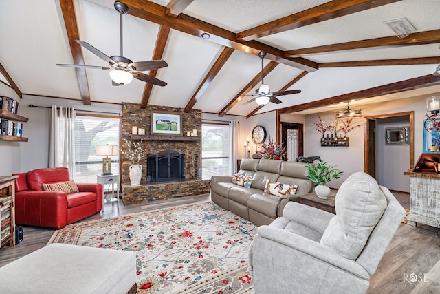 living room with lofted ceiling with beams, a healthy amount of sunlight, dark wood-type flooring, and a fireplace