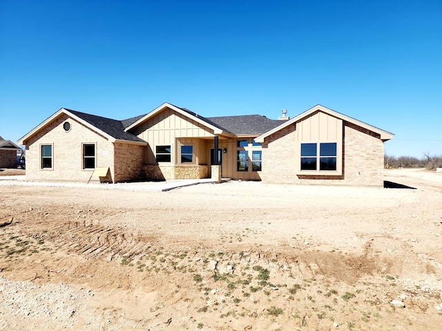 view of front of property with brick siding and board and batten siding