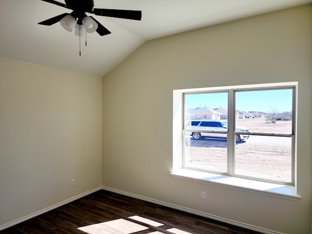 unfurnished room featuring lofted ceiling, dark wood-style floors, ceiling fan, and baseboards