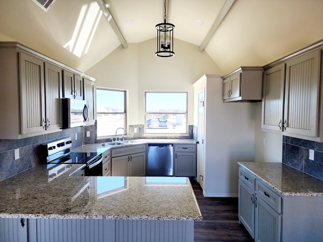 kitchen with vaulted ceiling with beams, hanging light fixtures, appliances with stainless steel finishes, a sink, and a peninsula