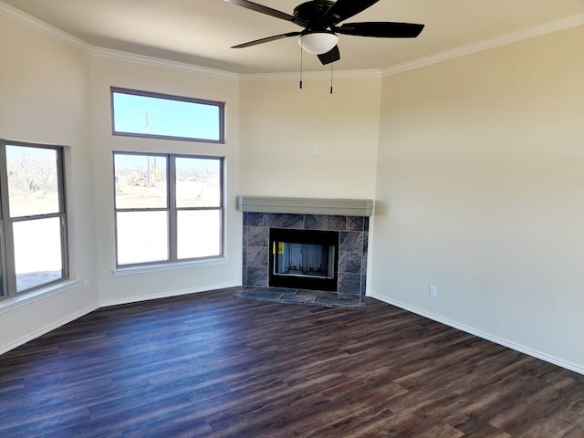 unfurnished living room with ornamental molding, a tile fireplace, dark wood finished floors, and baseboards