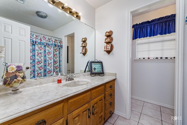 bathroom with baseboards, a textured ceiling, vanity, and tile patterned floors