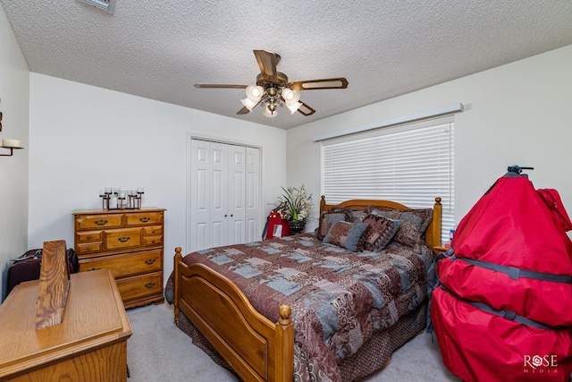 bedroom featuring light carpet, a textured ceiling, a ceiling fan, and a closet