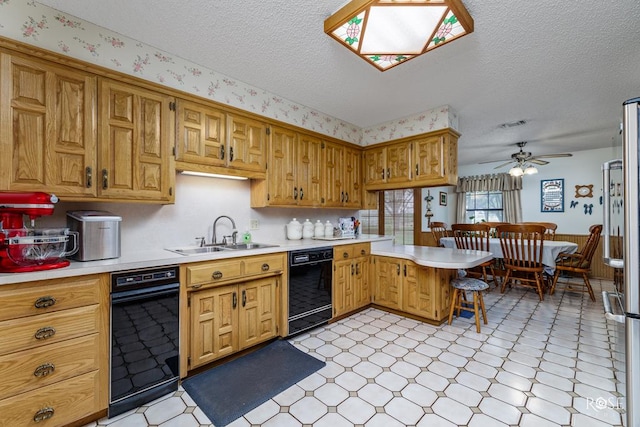 kitchen featuring black dishwasher, light floors, a peninsula, and a sink