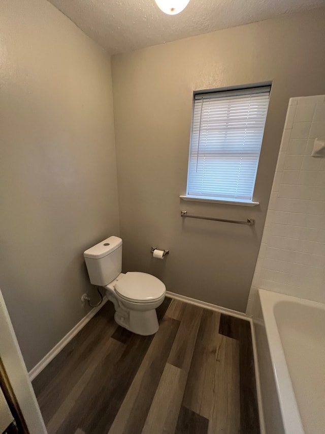 3222 Southland Blvd, San Angelo, TX 76904 - full bathroom with a textured ceiling, wood finished floors, a tub, and a shower