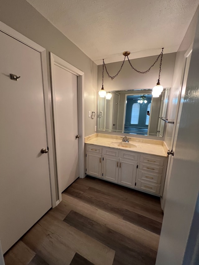 3222 Southland Blvd, San Angelo, TX 76904 - bathroom with wood finished floors, vanity, and a textured ceiling